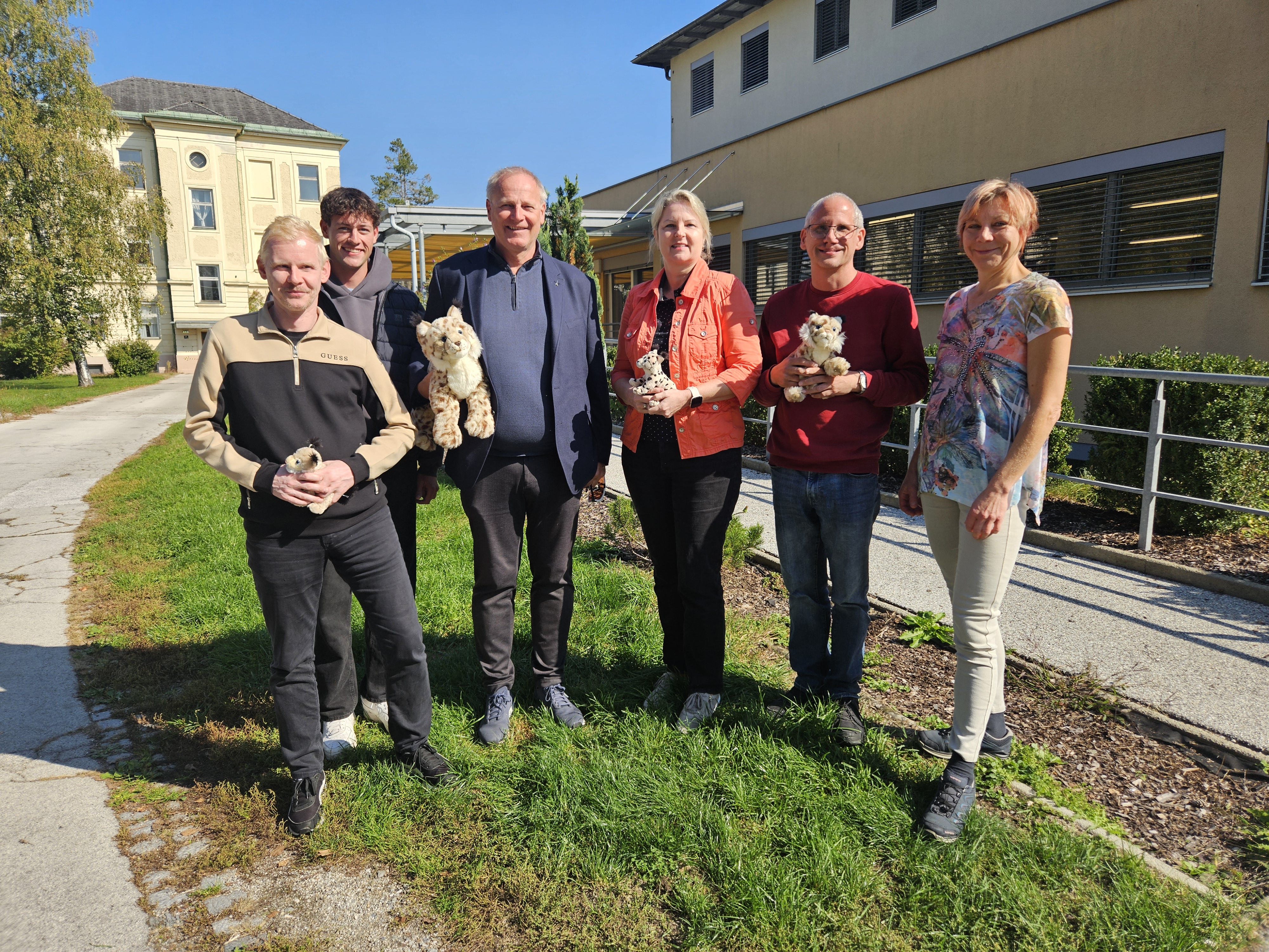 Das Team des Blinden- und Sehbehindertenverbands Kärnten mit Plüschluchsen vor dem August-Wurzer-Haus
